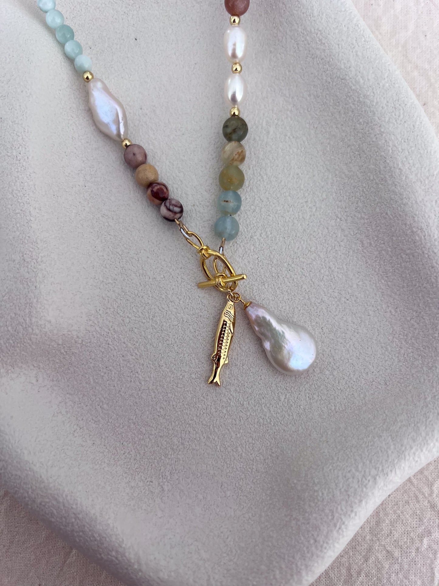 18k gold-filled toggle clasp with freshwater pearl and fish pendant on a handmade blue calcite and zebra jasper gemstone necklace.
