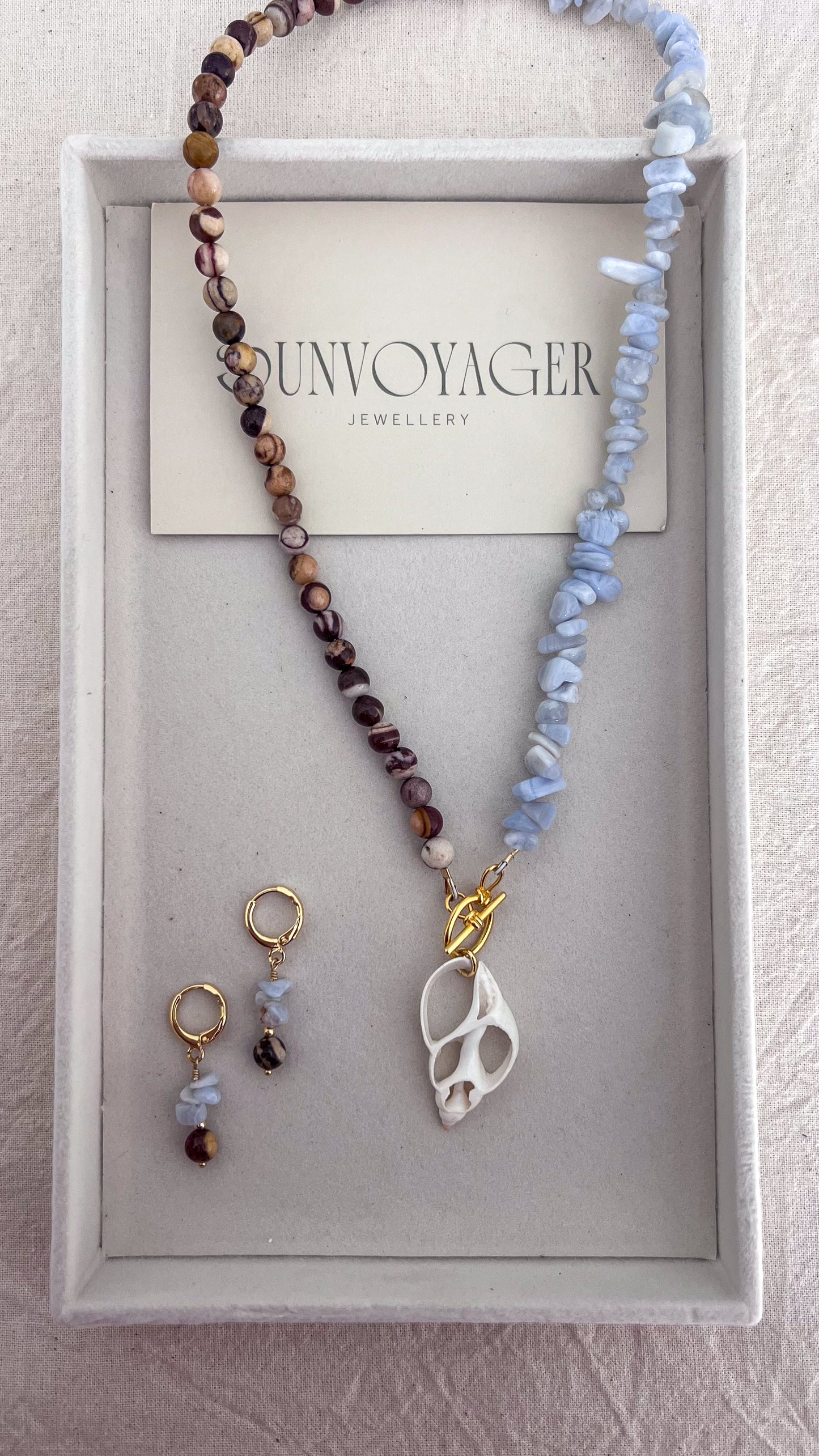 Handmade blue lace agate and natural zebra jasper gemstone necklace with gold-filled toggle clasp and statement shell pendant.