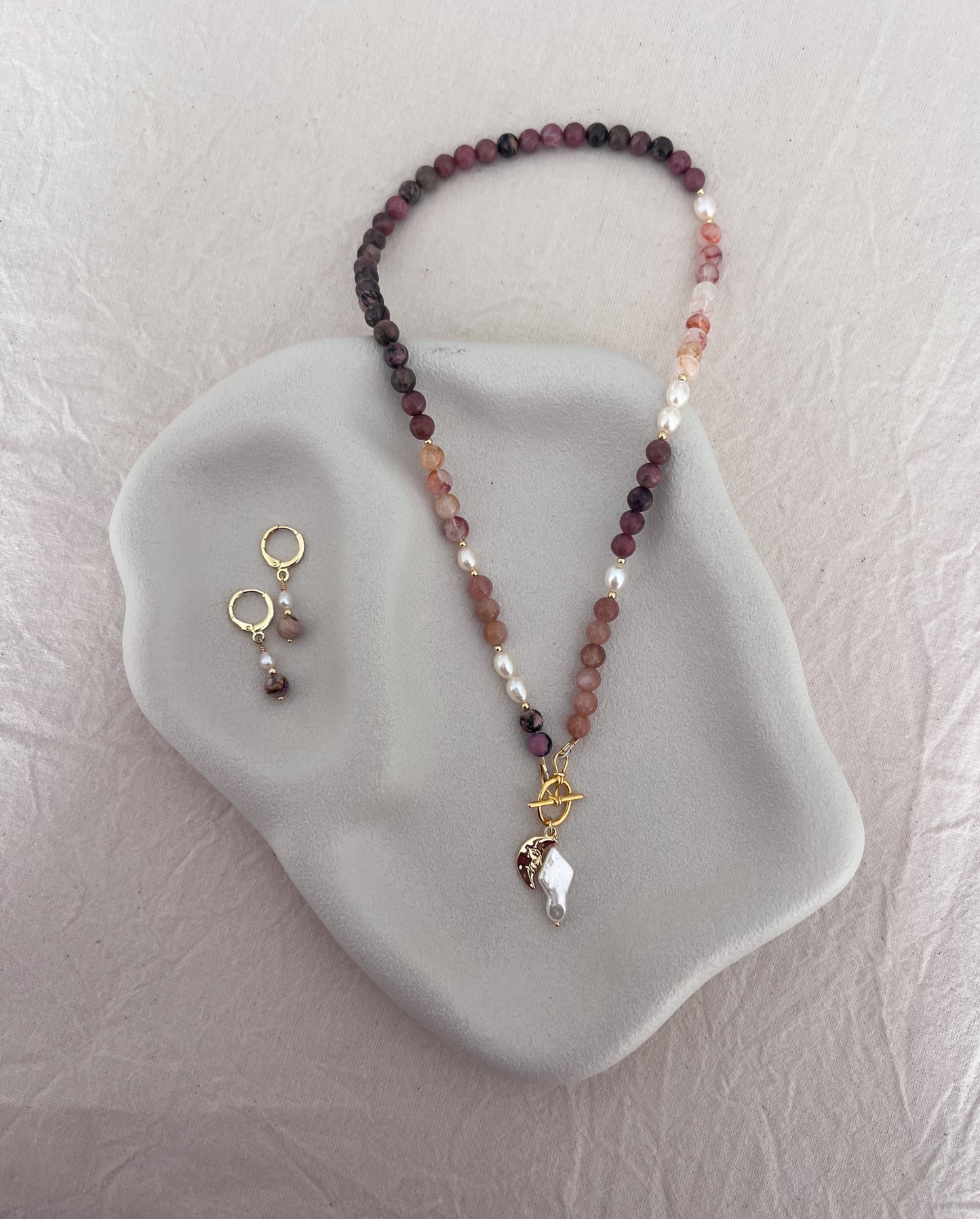One-of-a-kind red quartz, rhodolite, sunstone and freshwater pearl necklace with moon charm and matching gemstone earrings by SunVoyager Jewellery.