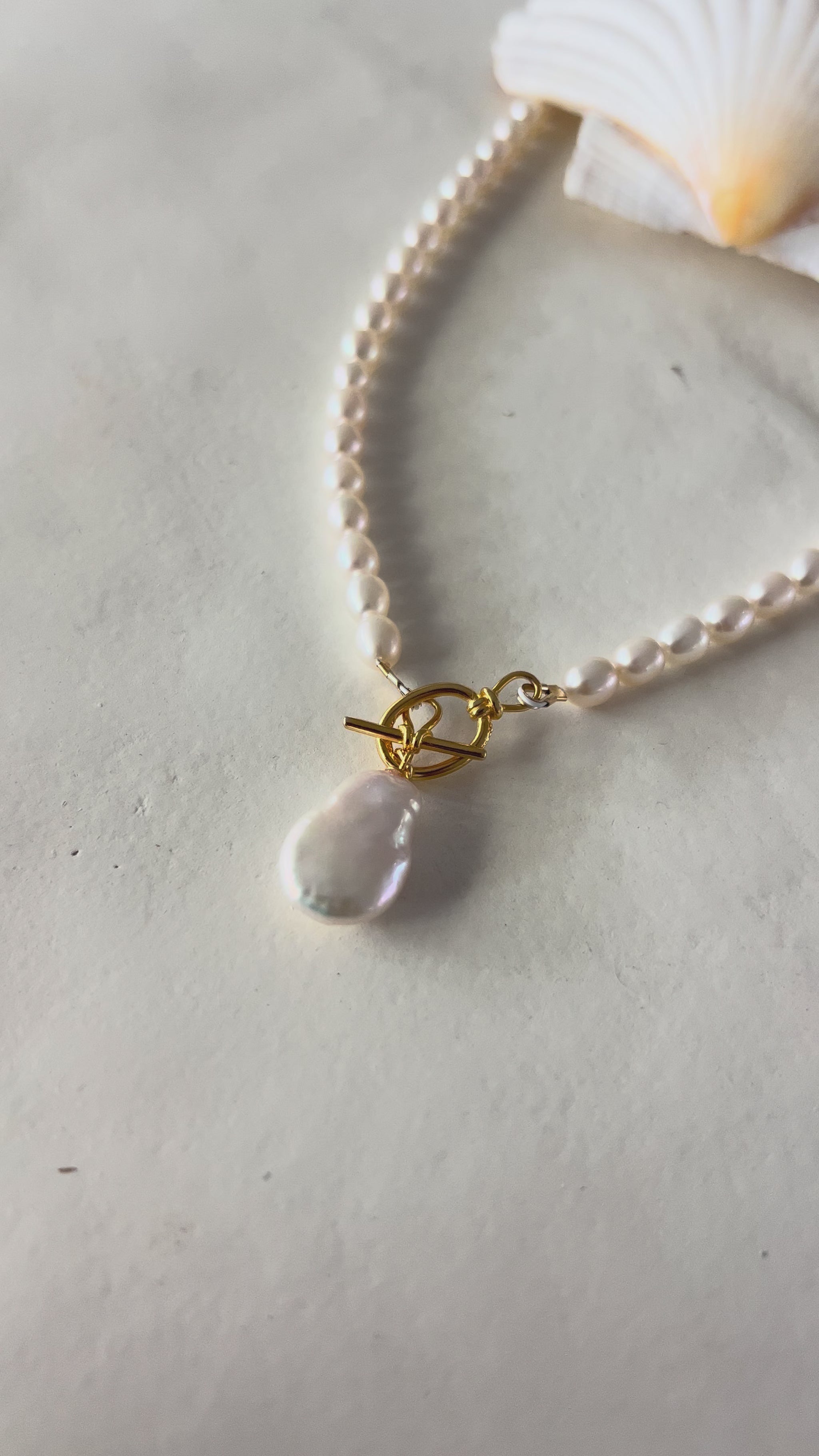 Handmade freshwater pearl necklace with gold filled toggle clasp and baroque freshwater pearl drop pendant, laid flat on sage green background — Solstice Necklace from the SunVoyager Solstice Collection, made in Tropical North Queensland, Australia